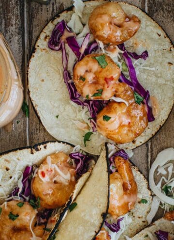 Bang bang shrimp taco with slaw and sauce.