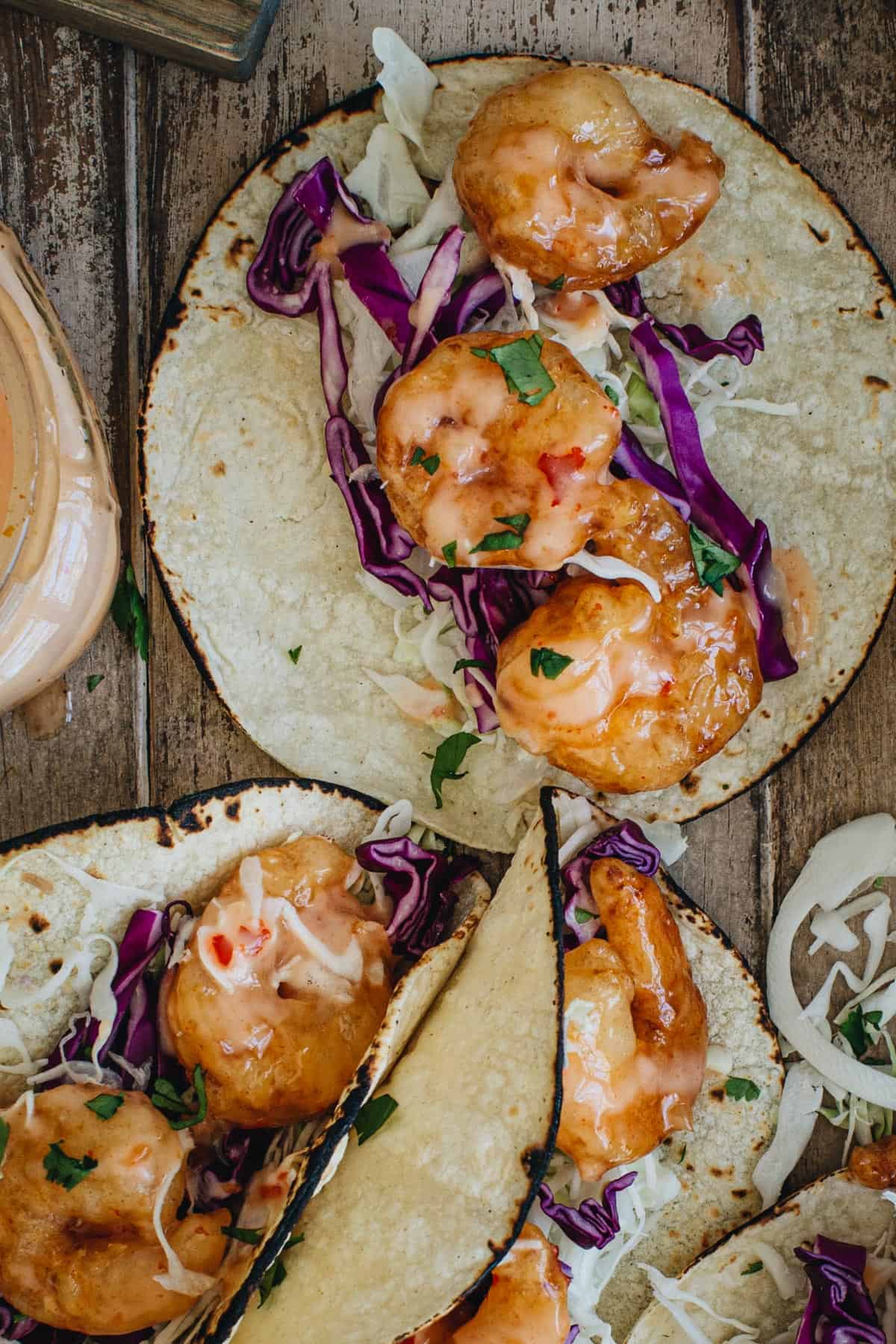 Bang bang shrimp taco with slaw and sauce.