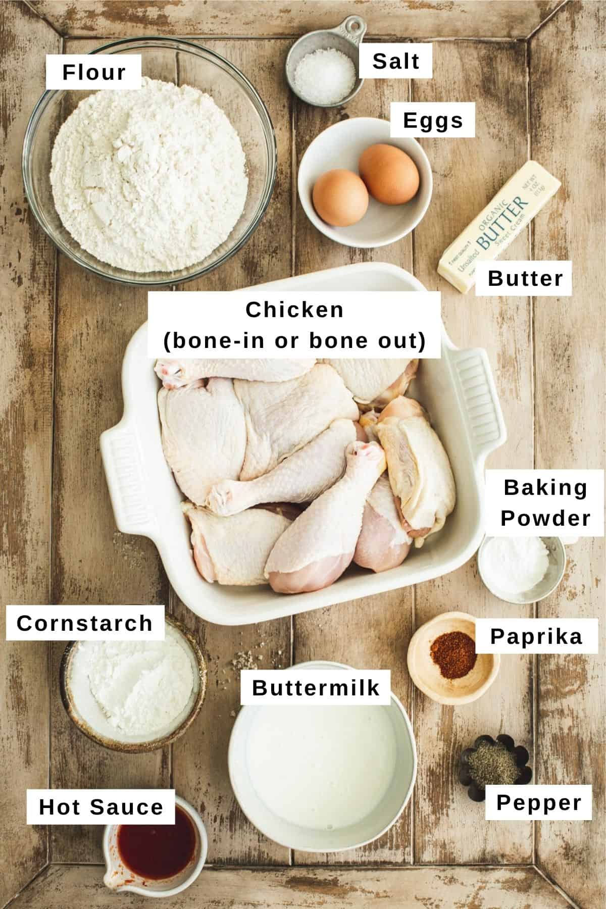 Oven-fried chicken ingredients in various bowls on a wooden board.