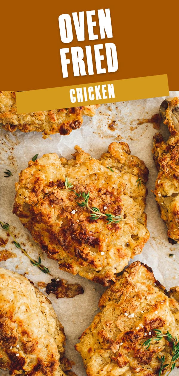 Oven-fried chicken pieces on parchment topped with fresh thyme and coarse salt.