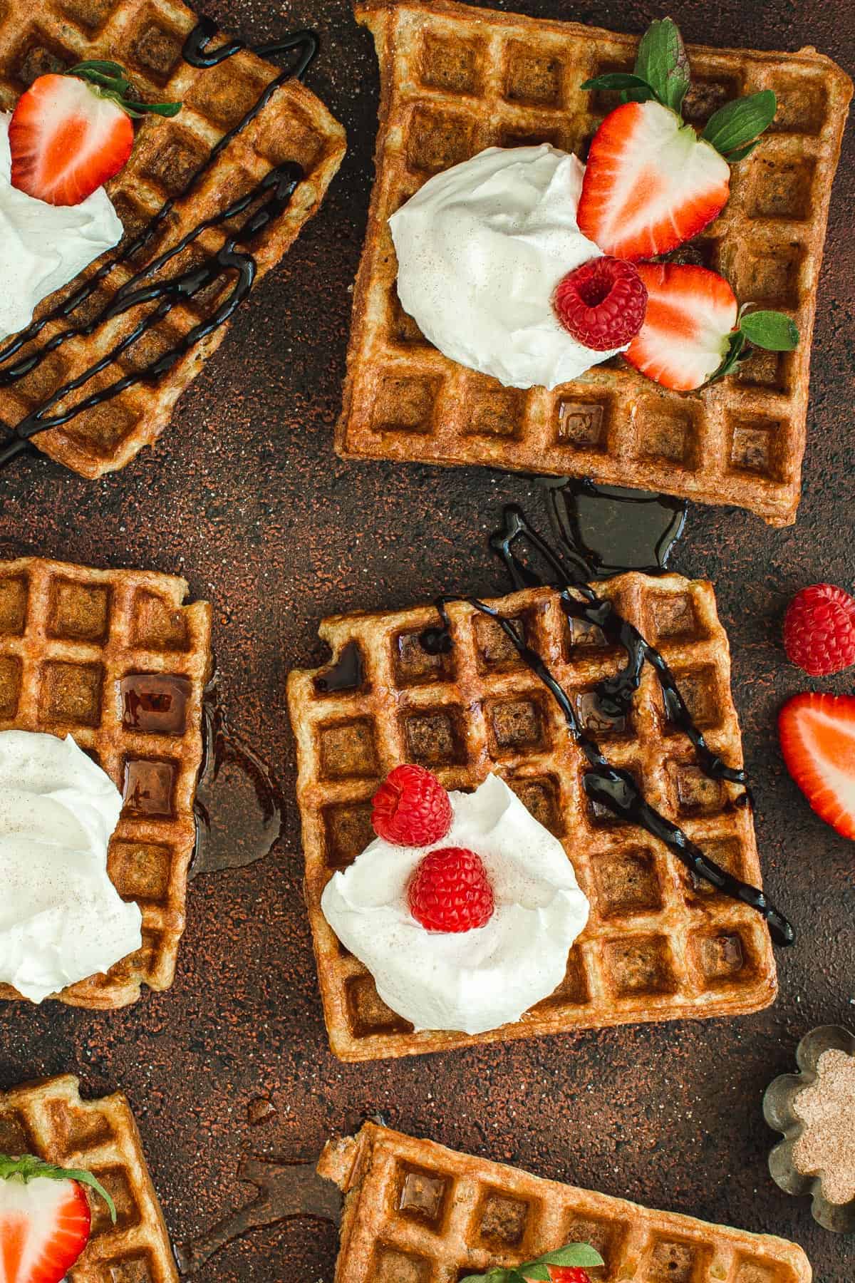 Protein waffles with whipped cream, chocolate syrup, and berries.