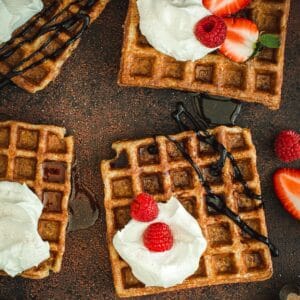 Protein waffles topped with whipped cream and strawberries.