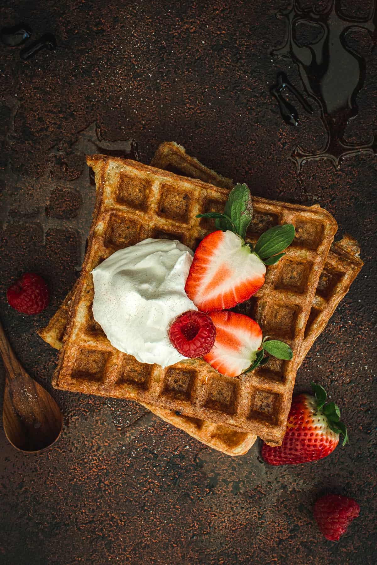 Protein waffles topped with whipped cream and berries.