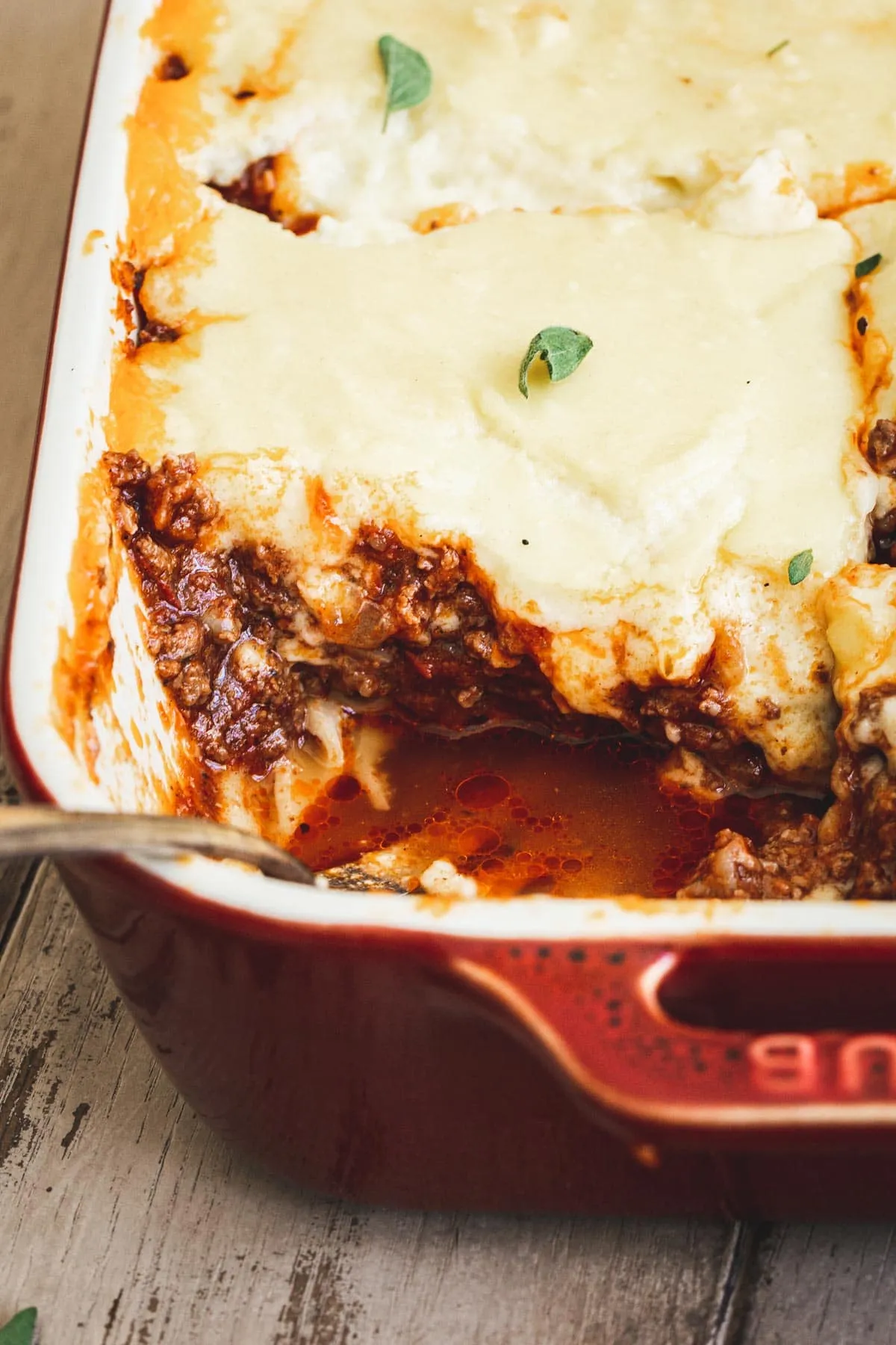 Pastitsio in a baking dish with a slice cut out.