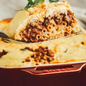 Greek lasagna slice on a spatula.