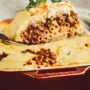 Greek lasagna slice on a spatula.