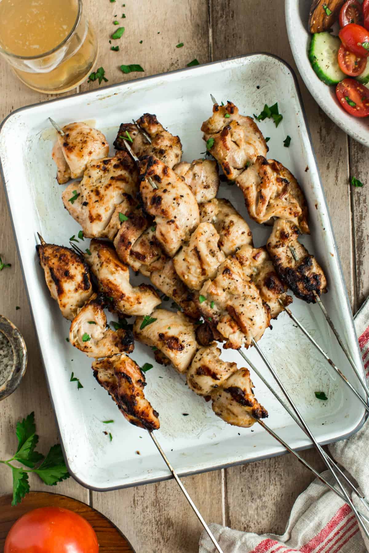 Yogurt chicken marinade chicken skewers on a white tray.