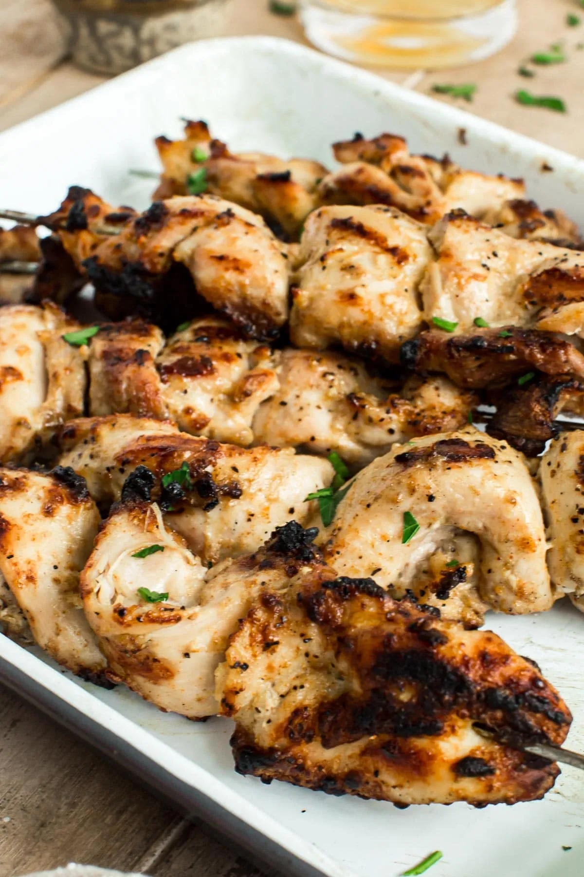 Yogurt marinated chicken skewers sprinkled with chopped fresh parsley.