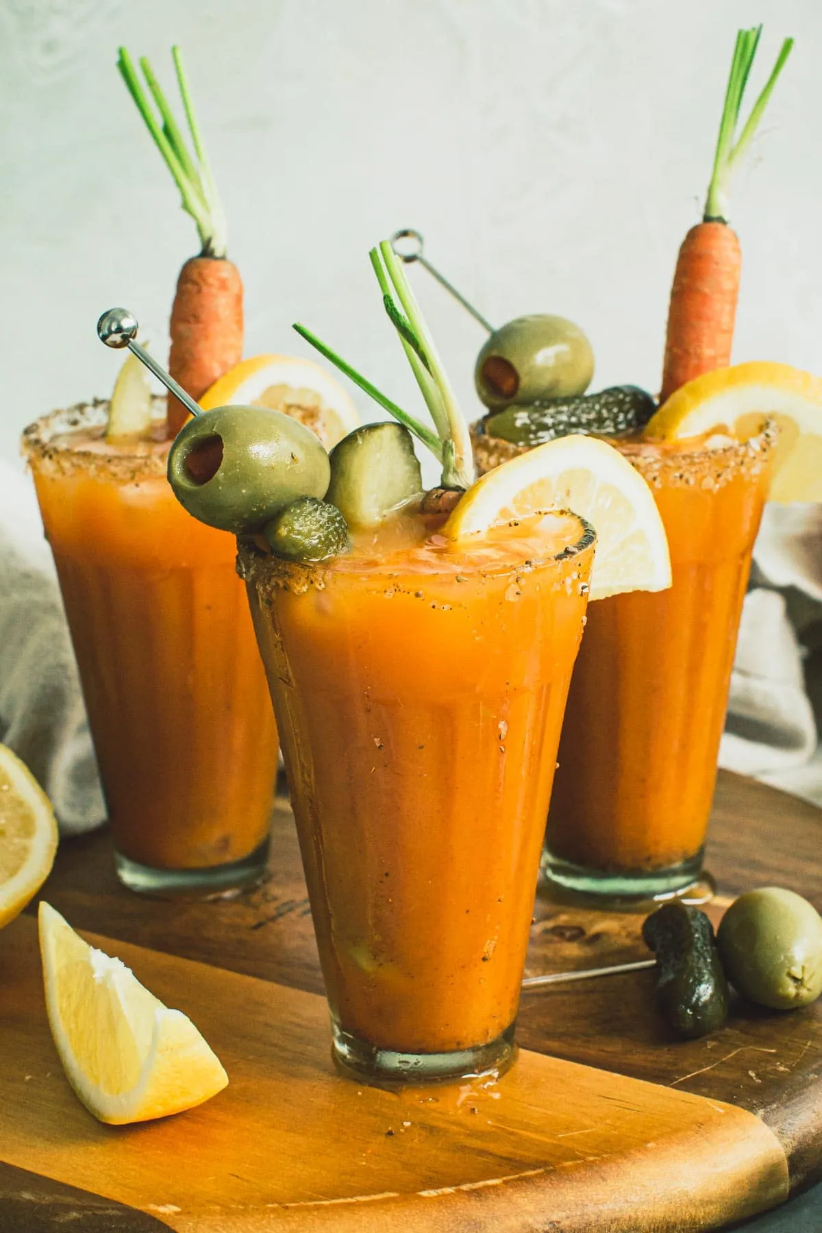 Easter cocktails topped with garnishes on a wooden board.