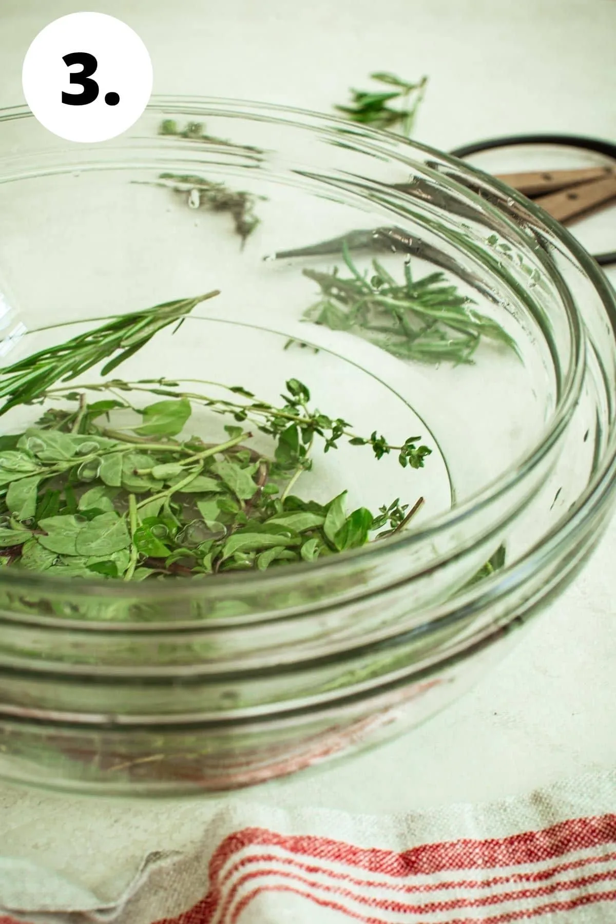 Herbs in citric acid solution with bowl nesting on top.