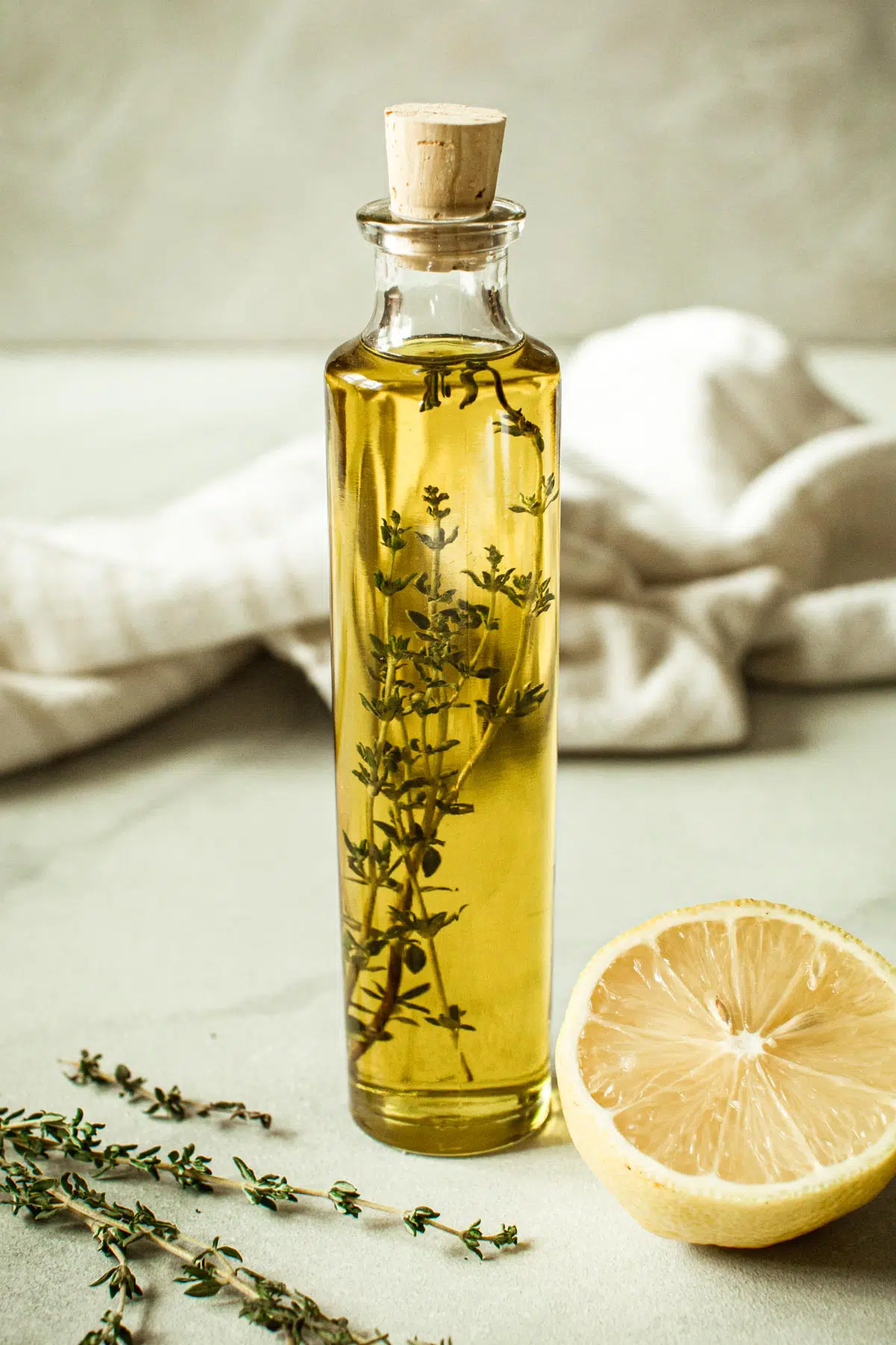 Lemon thyme infused olive oil in a bottle with a cork stopper.