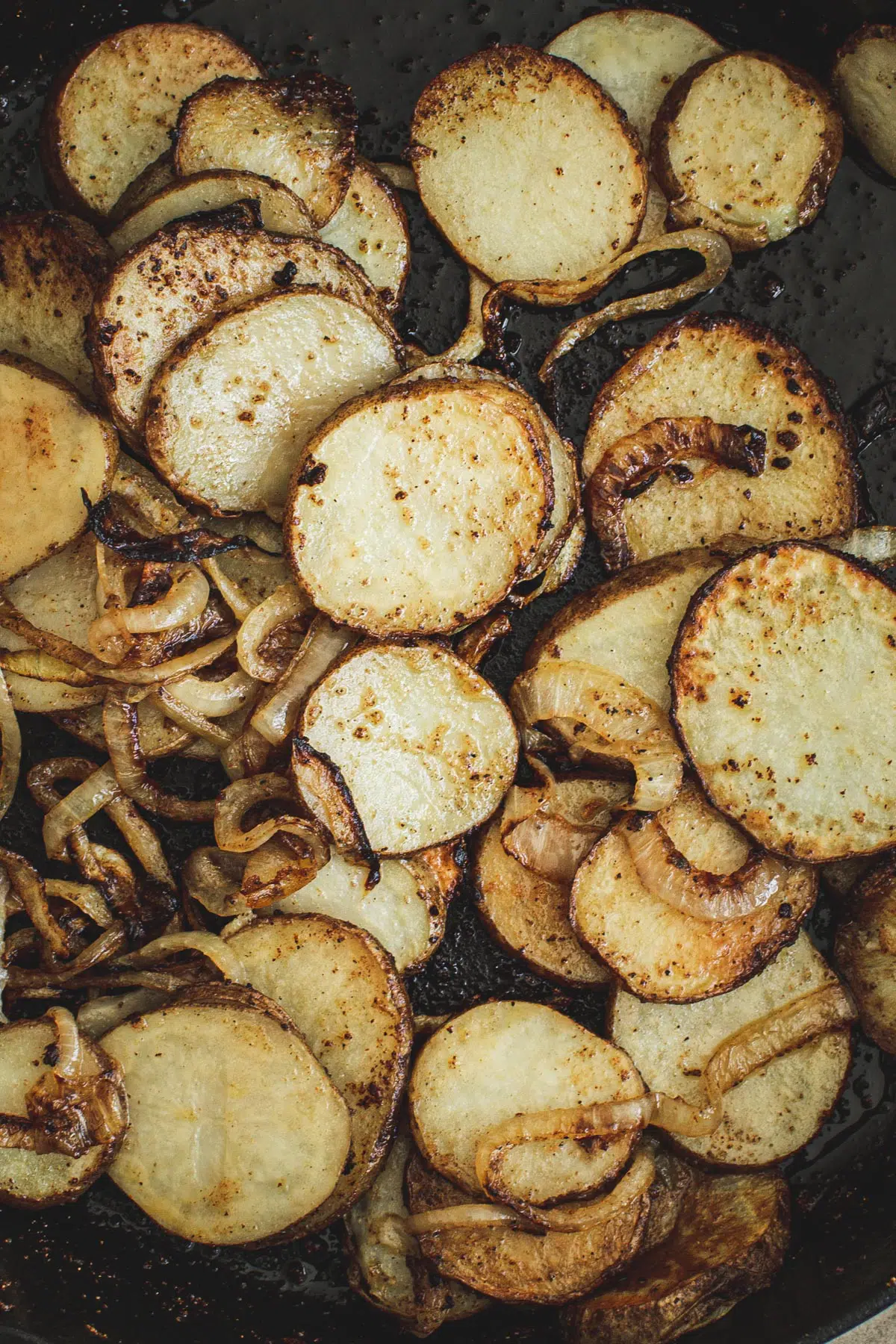 Fried potatoes and onions in an iron skillet.