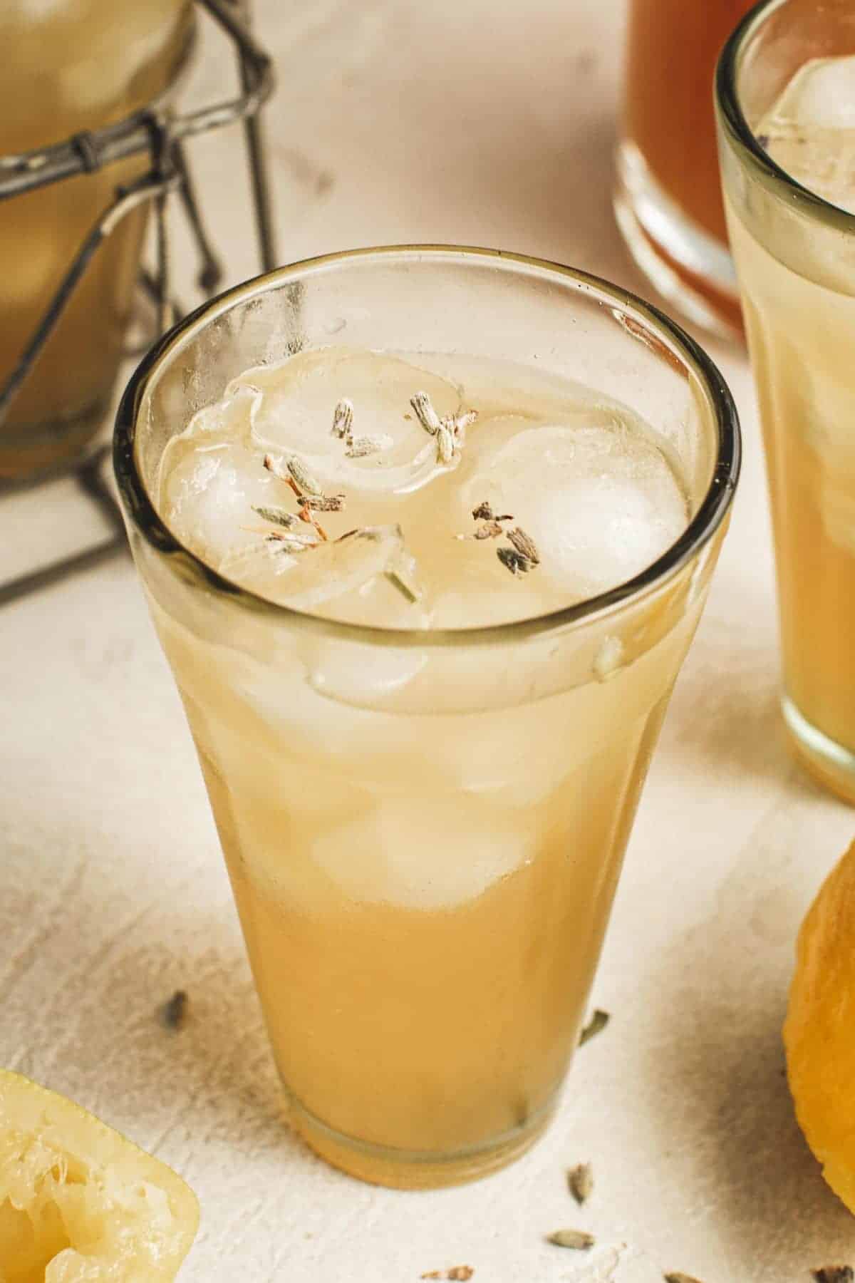 Glass of lavender lemonade topped with loose lavender tea granules.