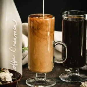 Homemade vegan coffee creamer being poured into a coffee mug filled with coffee.