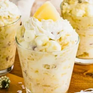 Pineapple jello salad in a jar topped with whipped cream.