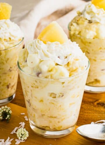 Pineapple jello salad in a jar topped with whipped cream.