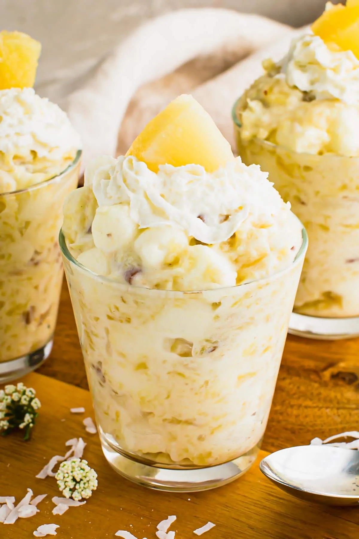 Pineapple jello fluff topped with whipped cream and pineapple slices.