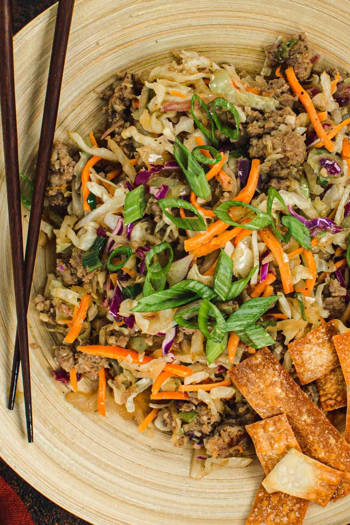 Egg roll in a bowl with chopsticks.
