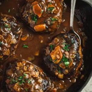 Salisbury steak with mushroom gravy in a skillet.