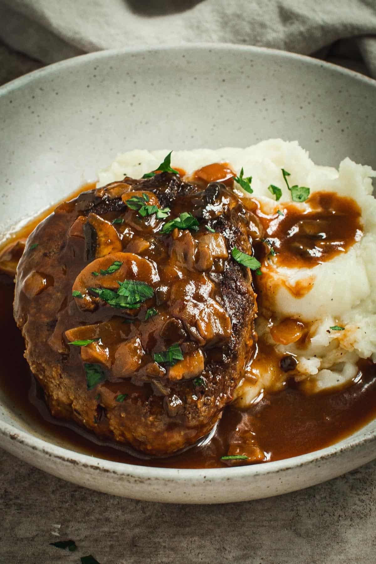 Hamburger steak with mushroom gravy and mashed potatoes.