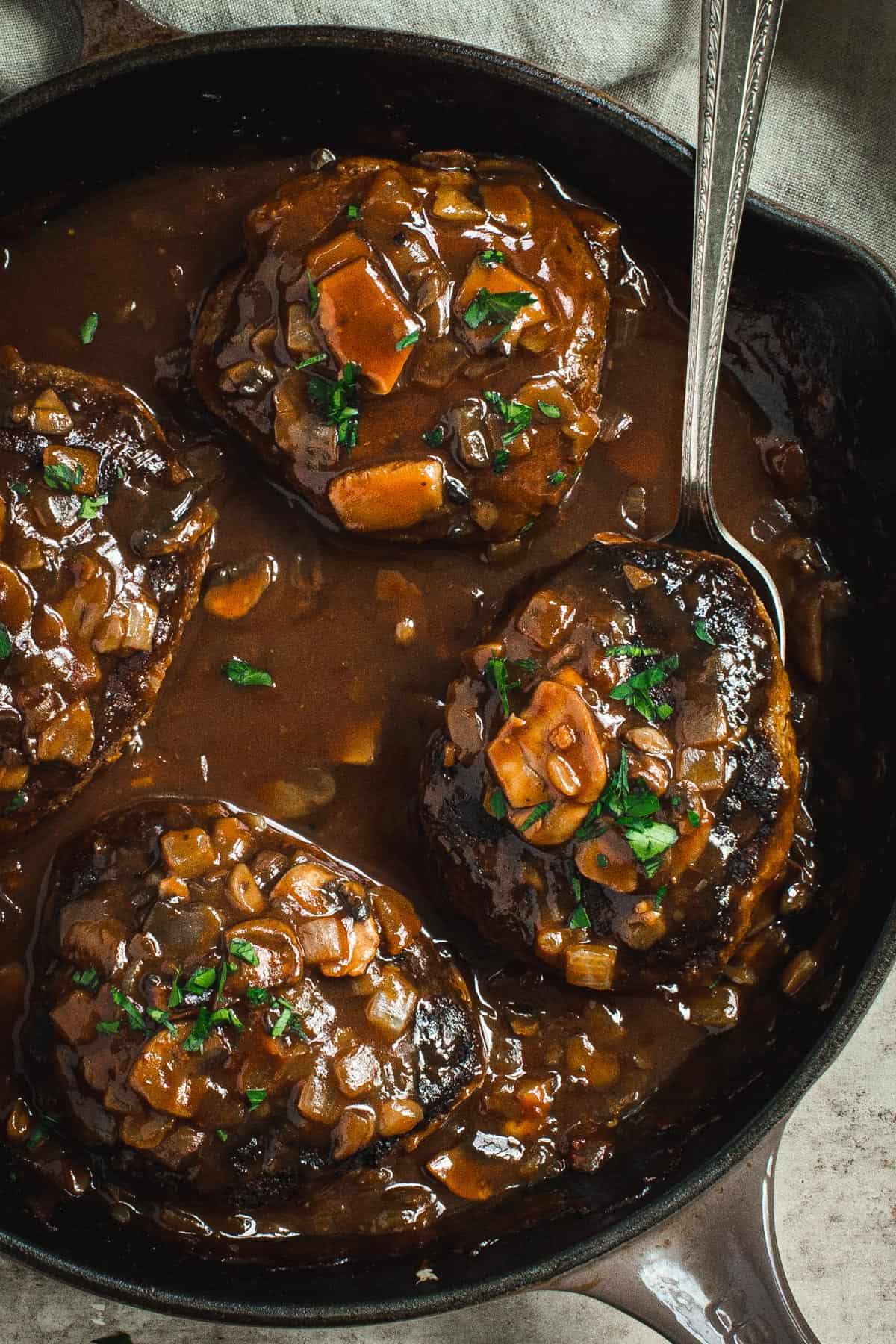 Salisbury steak with mushroom gravy in a skillet.