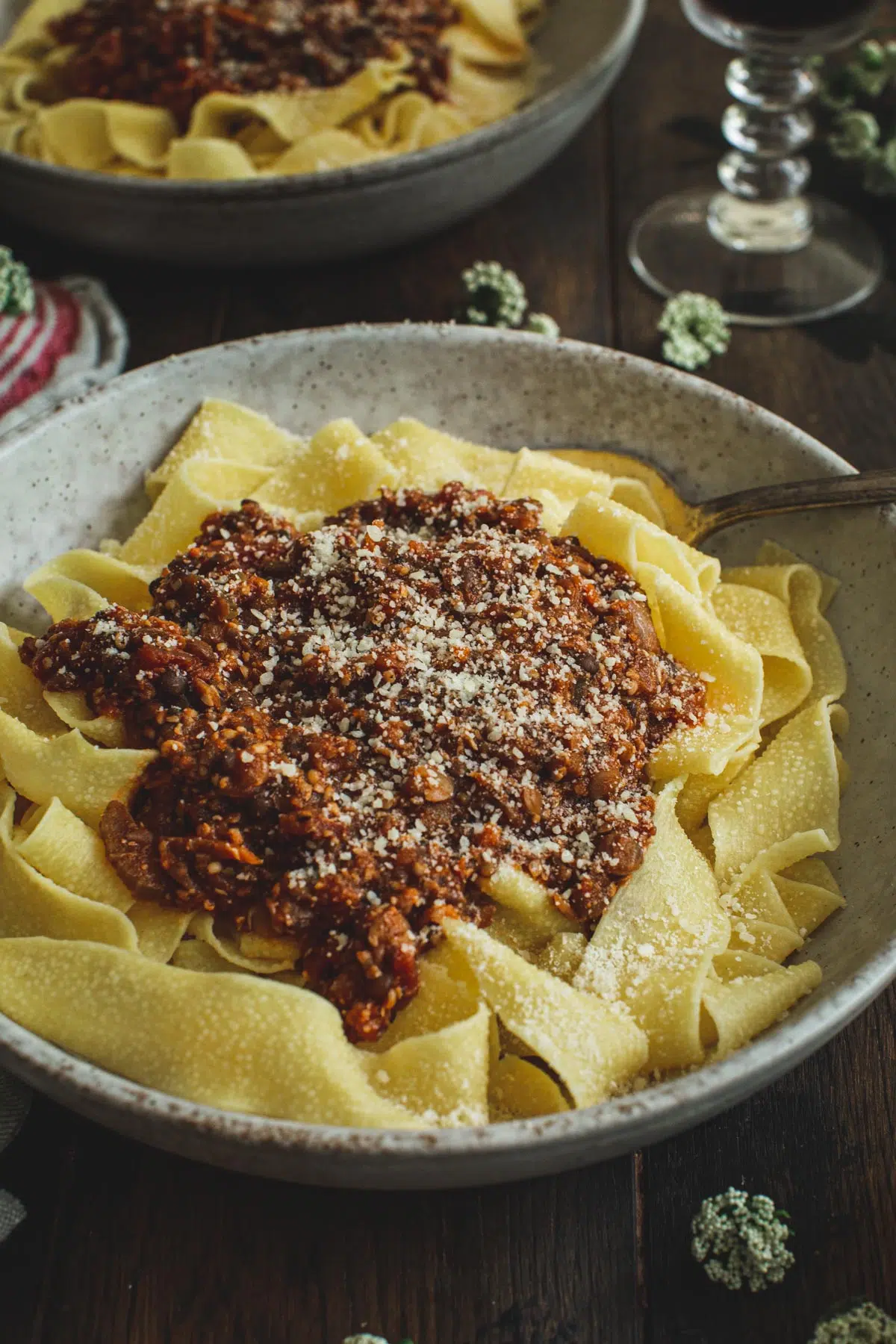 Lentil bolognese over pappardelle noodles topped with parmesan cheese.
