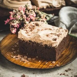 Slice of brownie cake with milk chocolate frosting.