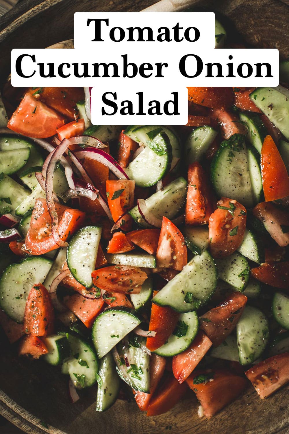 Tomato cucumber onion salad in a wooden bowl.