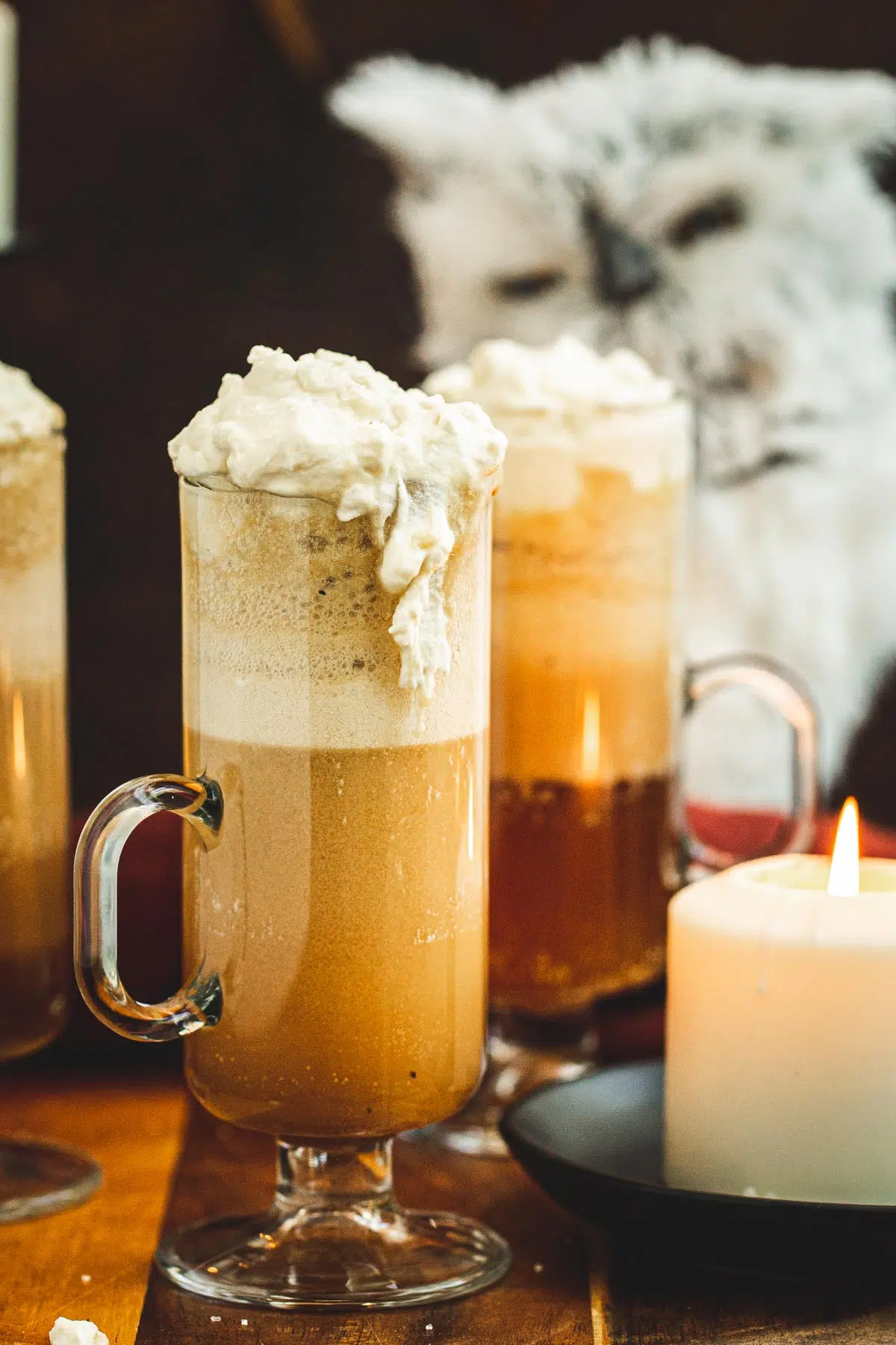 Harry Potter butterbeer in a tall glass with whipped cream spilling over the side.