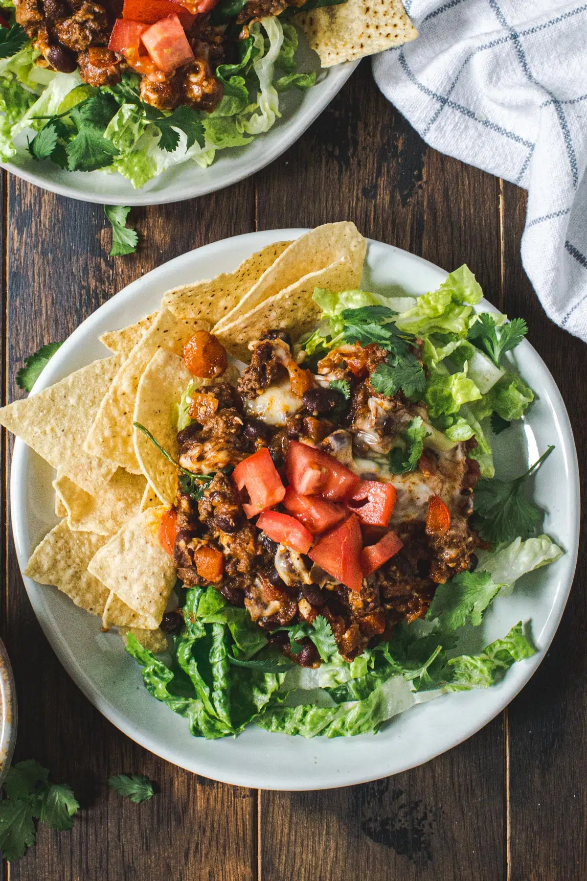 Mexican casserole with ground beef over lettuce and tortilla chips.