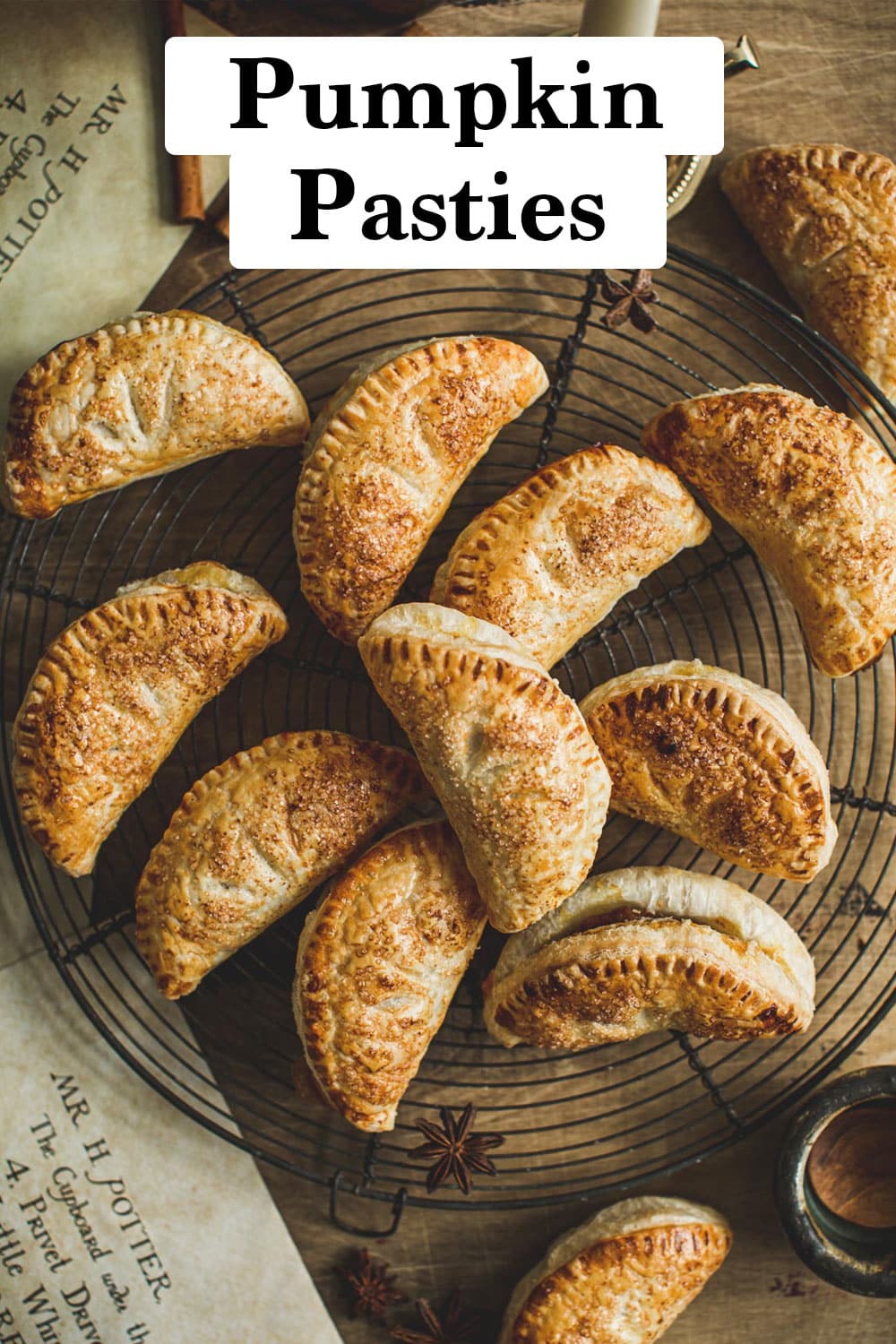 Pumpkin pasties on a wire rack sitting on a wooden board.