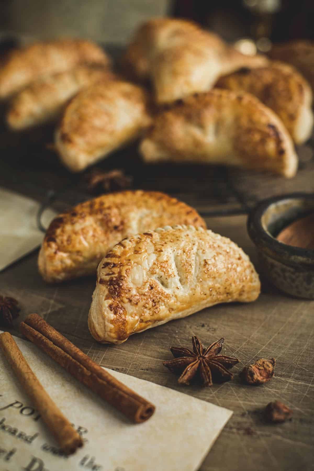 Harry Potter pumpkin pasties on a wire rack with whole spices surrounding them.