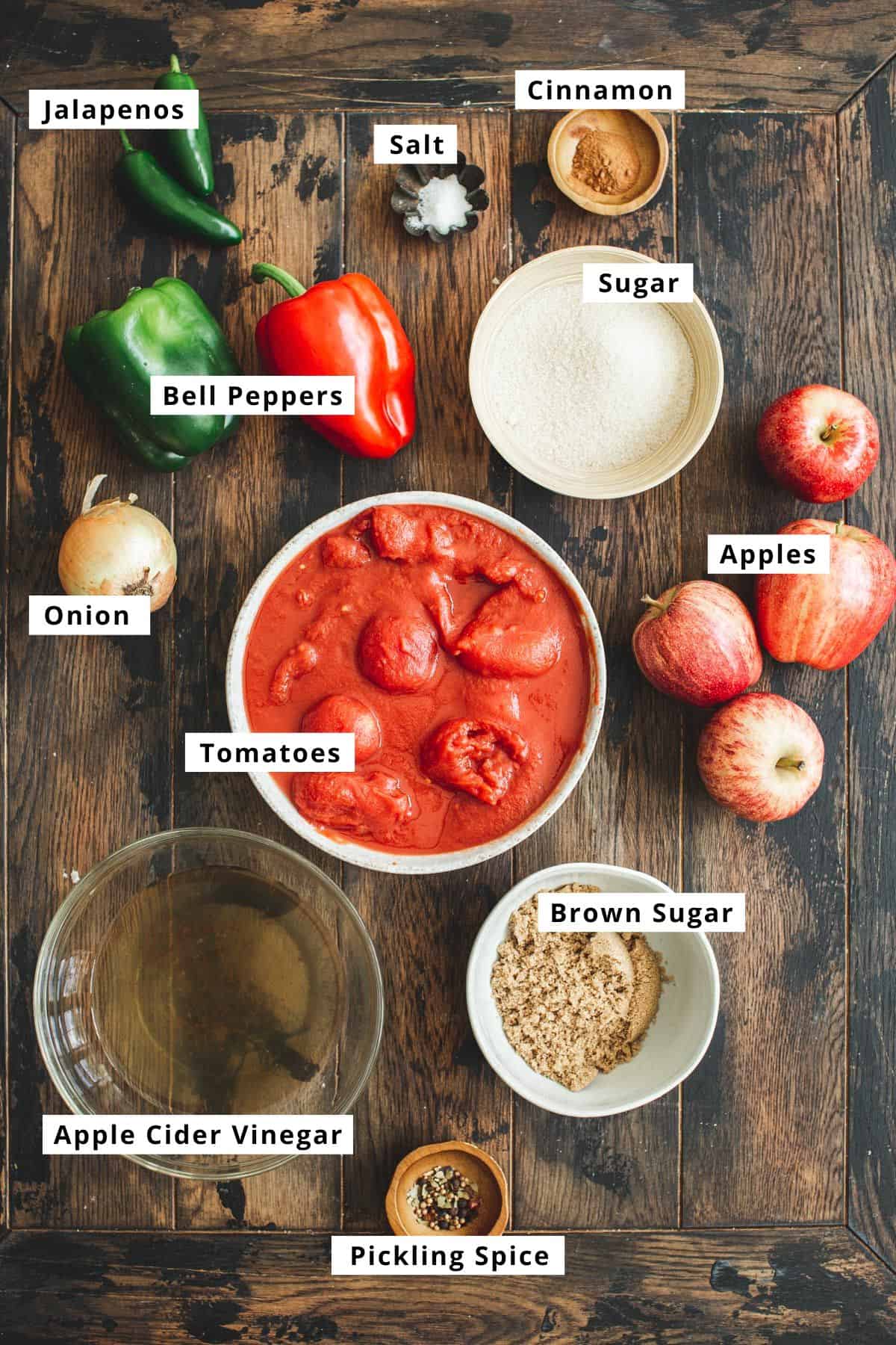 Ingredients to make the recipe for apple salsa on a wooden table.