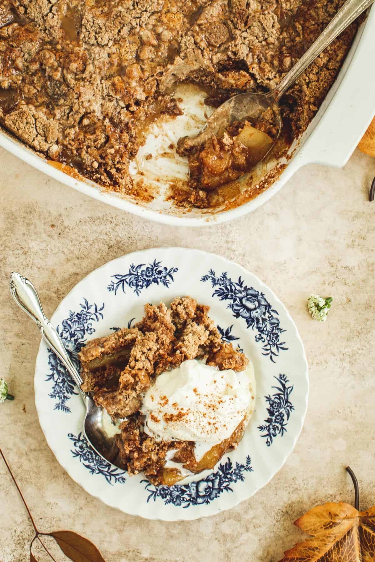 Easy apple dump cake covered with whipped cream in a dessert dish.