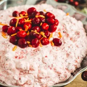 Cranberry fluff salad topped with fresh cranberries and orange peel.