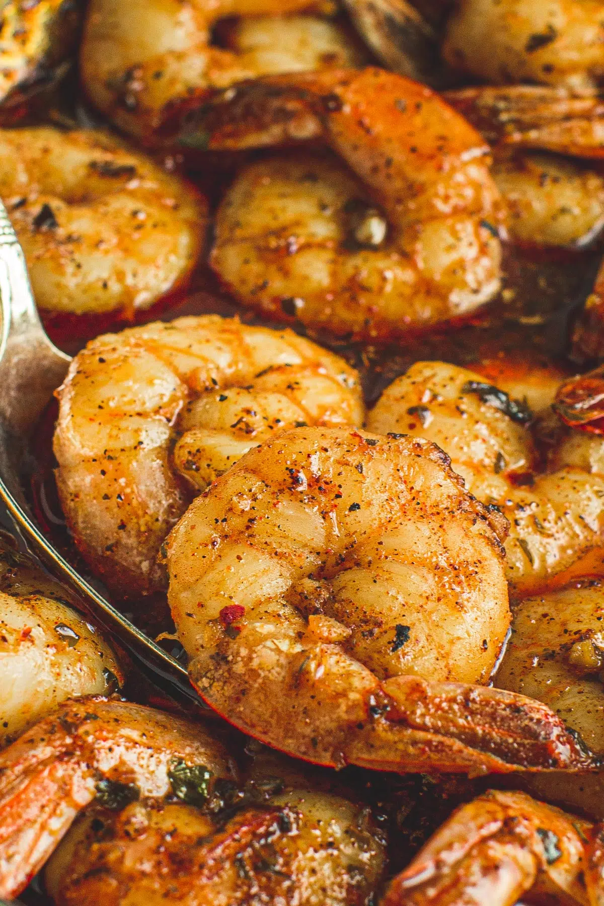 Honey garlic shrimp in a silver spoon.
