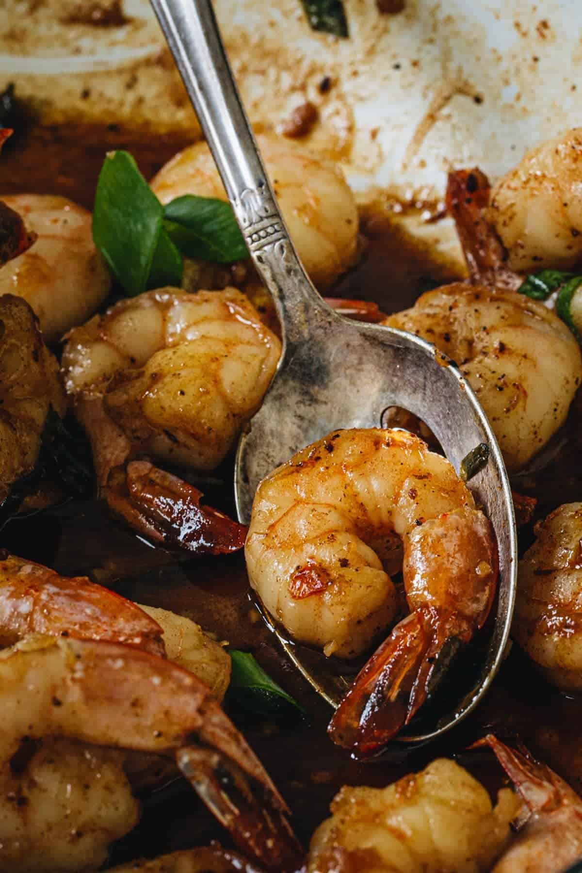 Cajun shrimp on a silver serving spoon.