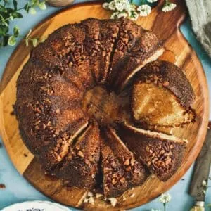 Jamaican rum cake sliced on a round wooden cutting board.