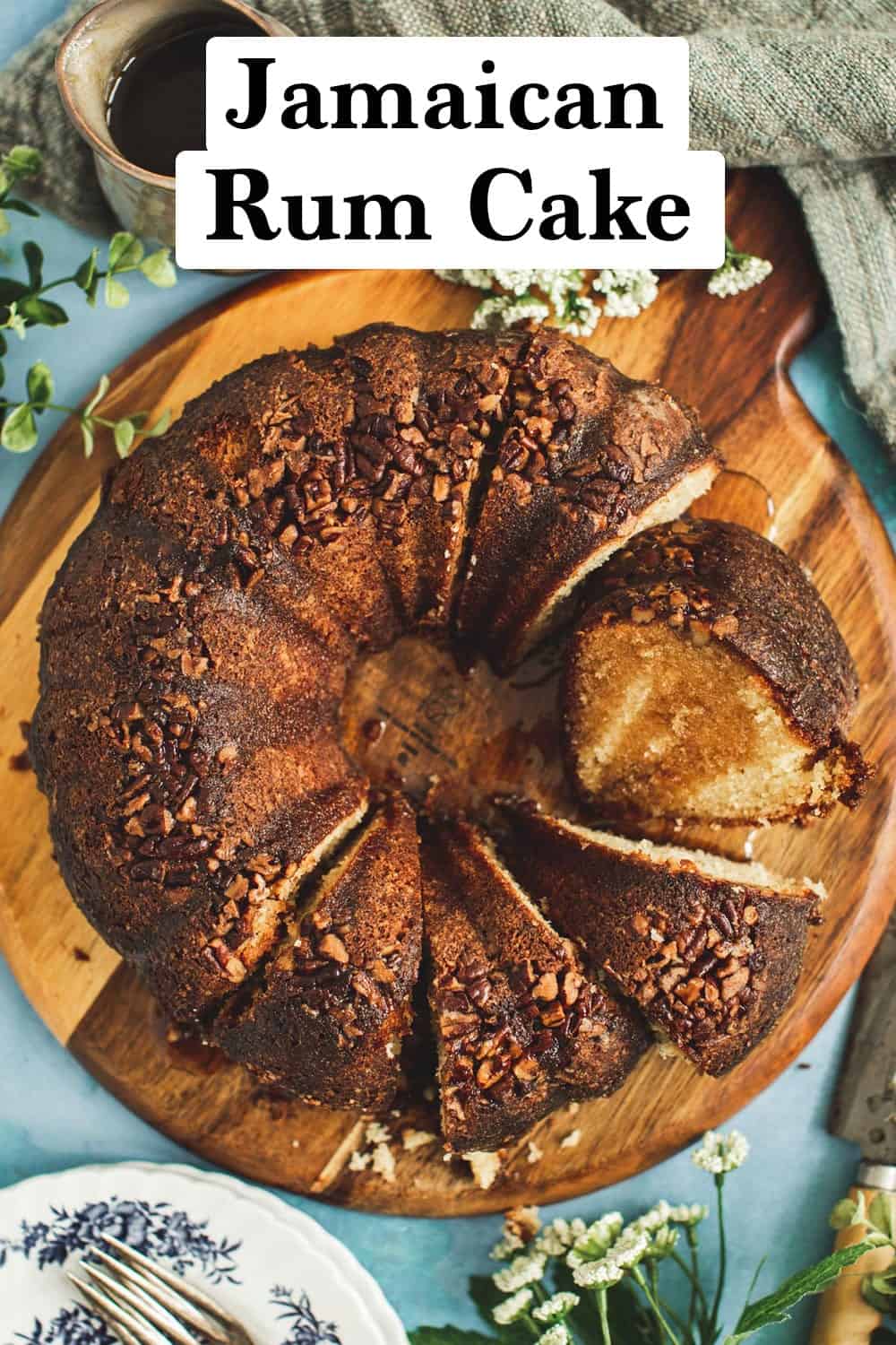 Jamaican rum cake sliced and drizzled in rum syrup sitting on a round cutting board.