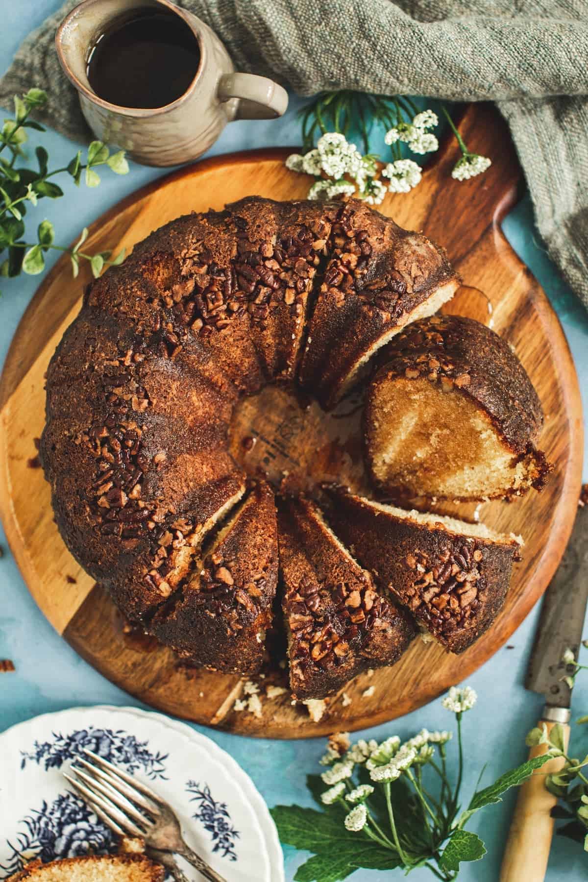 Jamaican rum cake sliced on a round wooden cutting board.