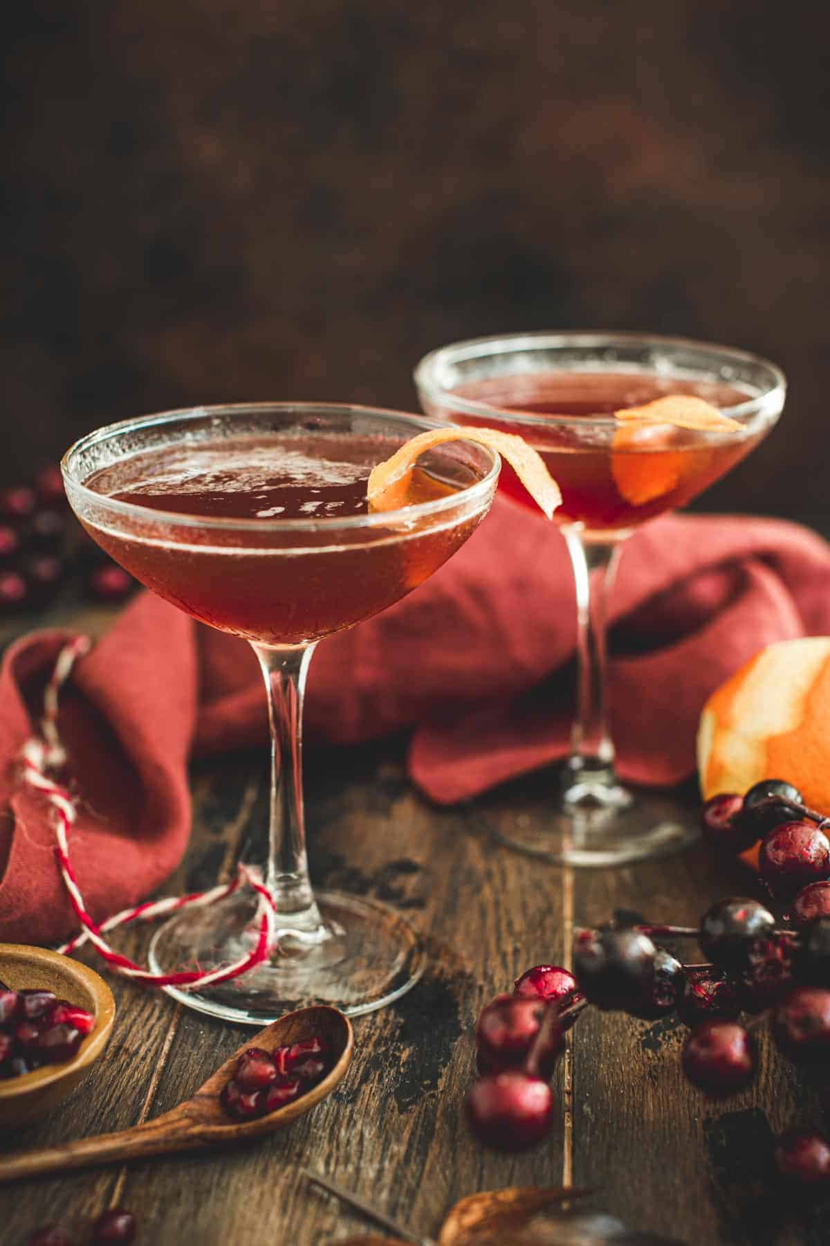 Pomtini drinks in martini glasses garnished with orange peel.