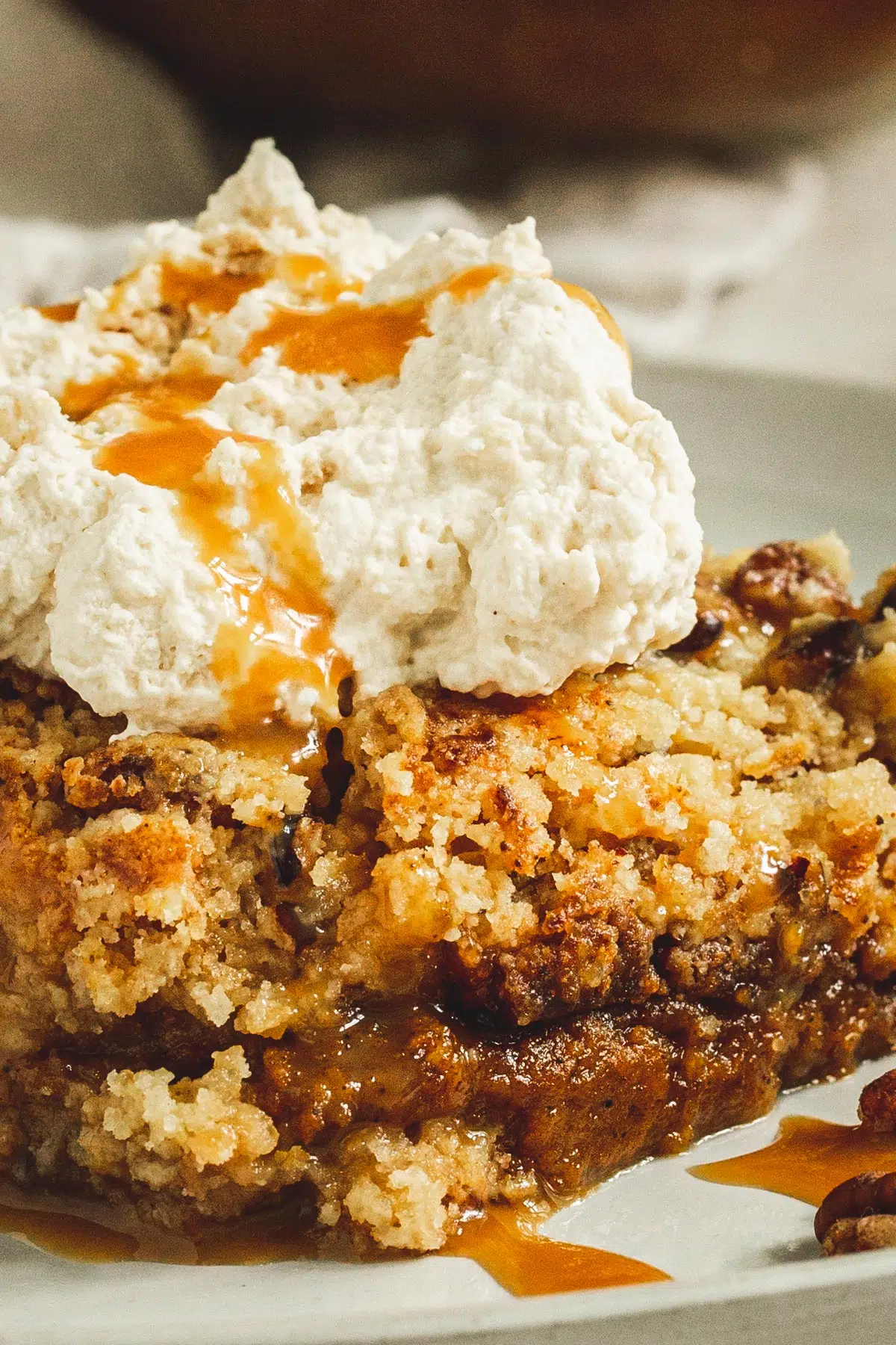 Pumpkin pie dump cake topped with whipped cream and caramel sauce.