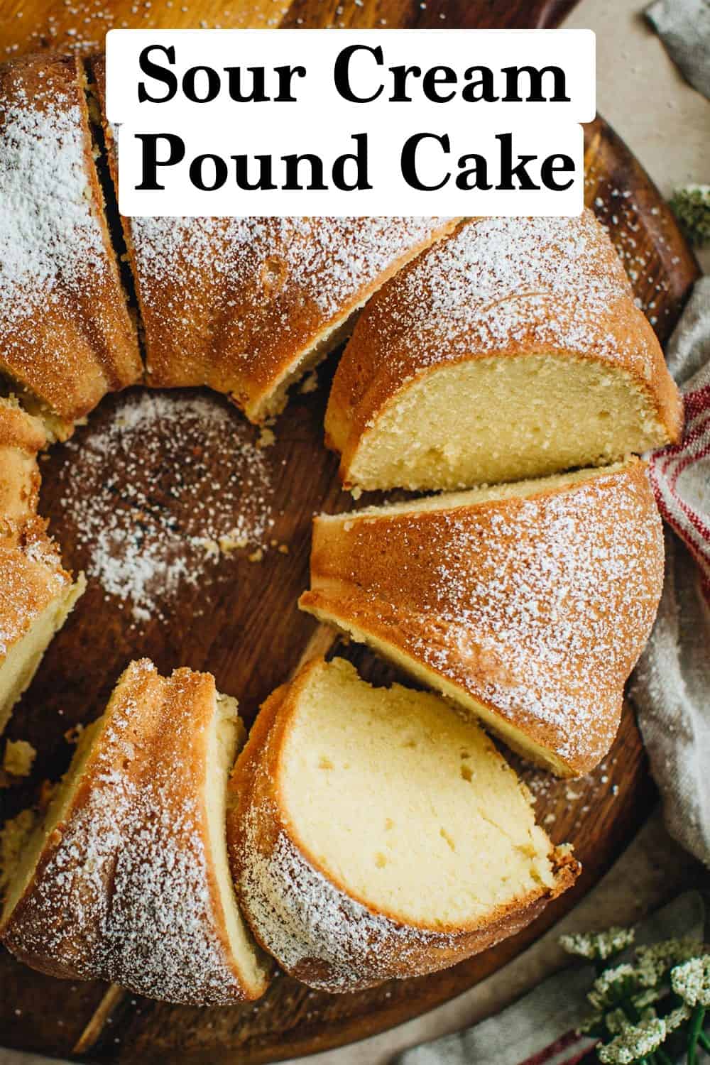 Sour cream pound cake sliced sitting on a wooden cutting board.