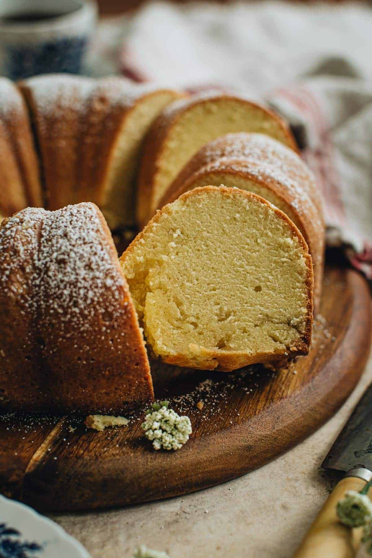 Sliced sour cream pound cake with powdered sugar dusted on top.