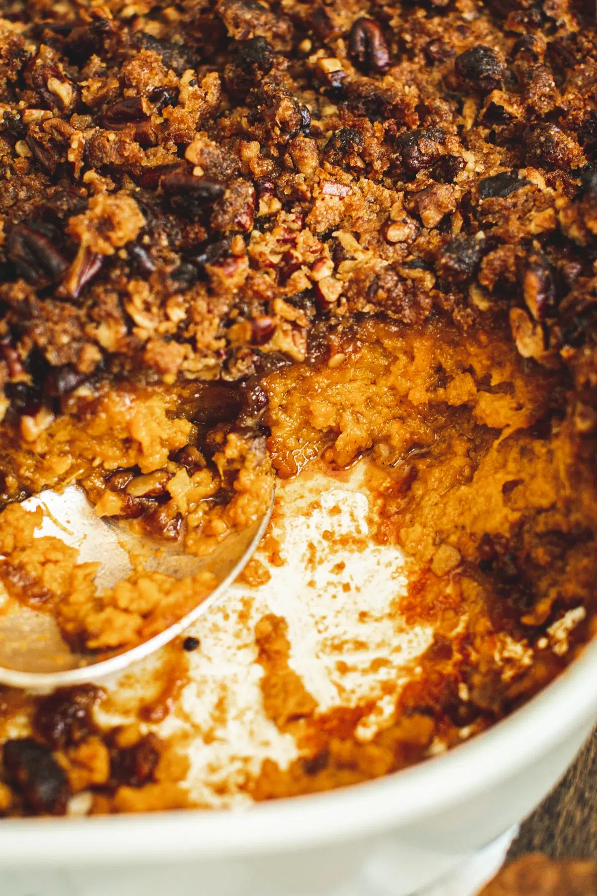 Sweet potato soufflé close up with a silver serving spoon.