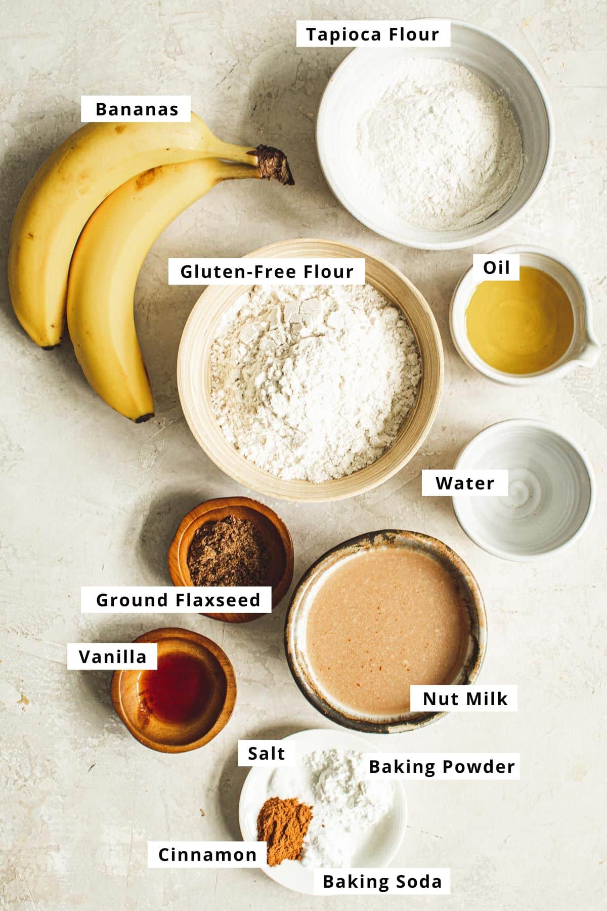 Vegan banana pancakes ingredients in various bowls.