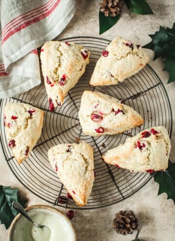 Cranberry orange scones on a round wire rack.