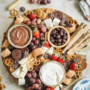Dessert charcuterie board with plates next to it.