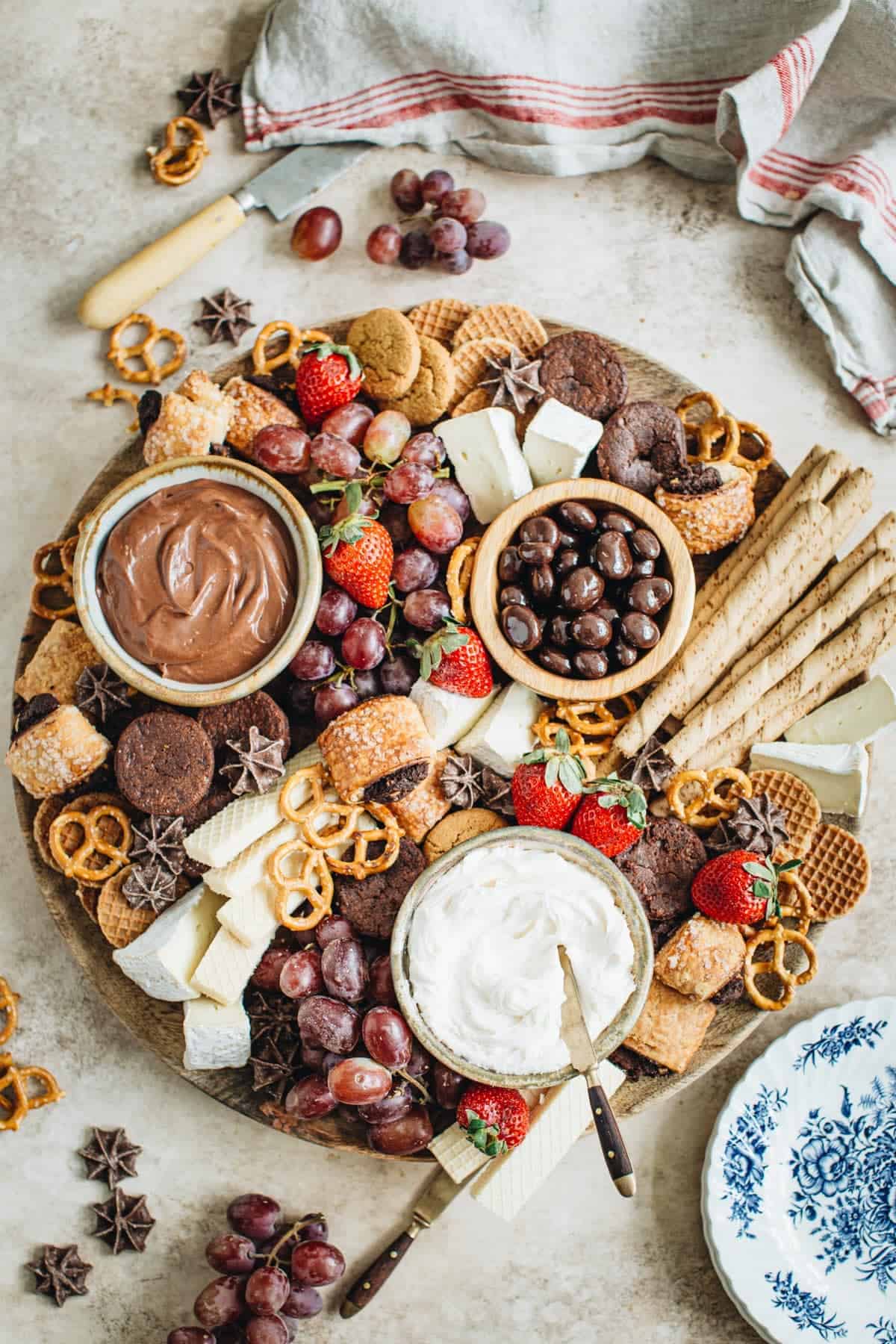 Dessert charcuterie board with plates next to it.