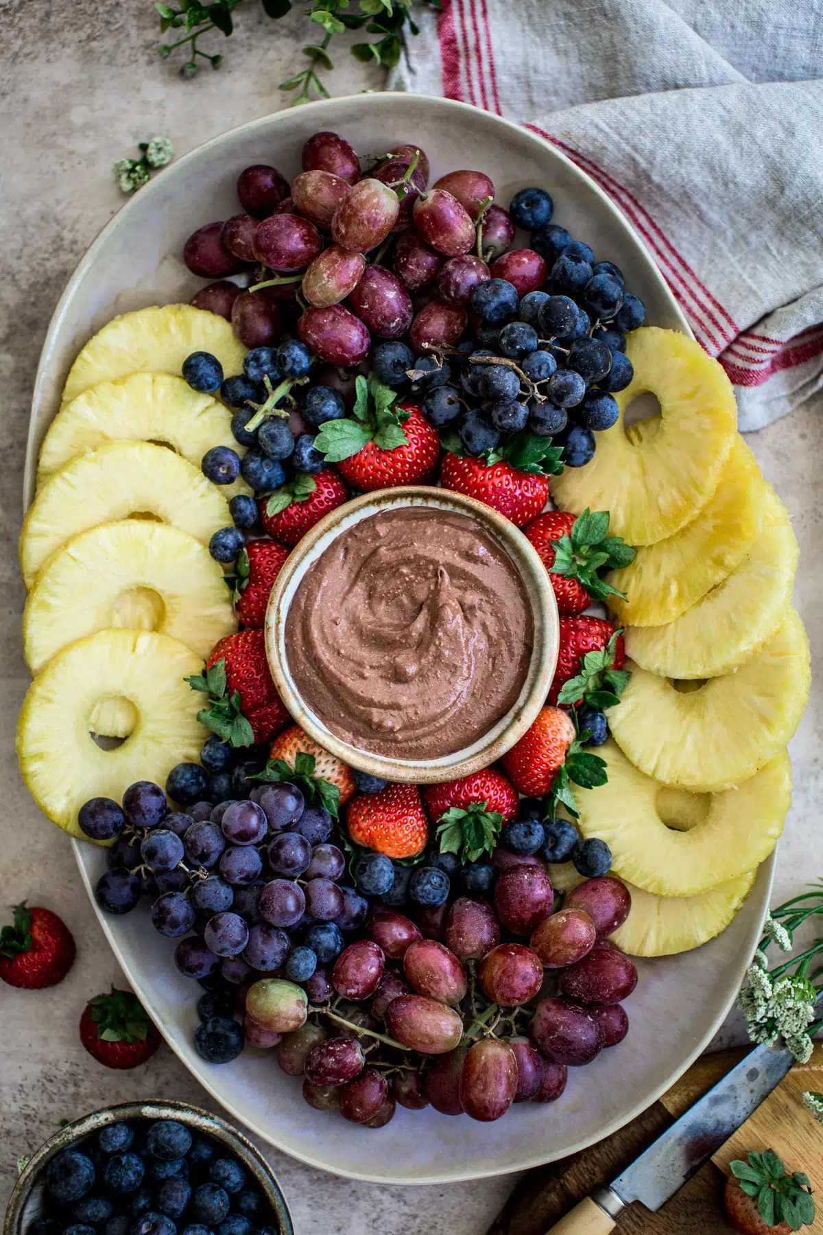 Easy fruit tray with fresh fruit and a chocolate fruit dip in the center.